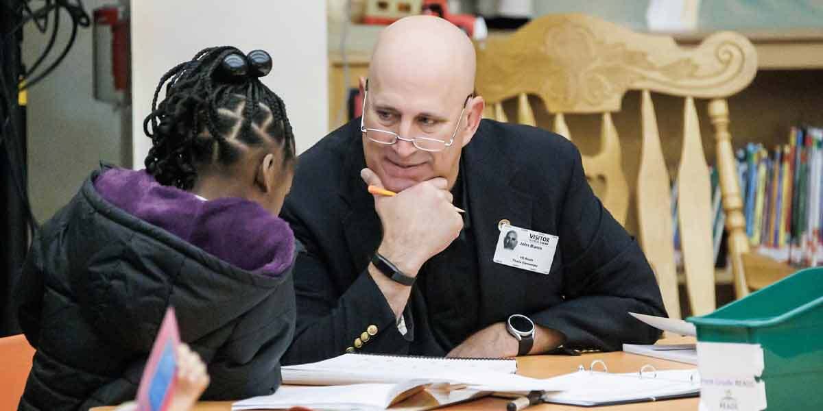 Man Holding Pencil Helping Child Write