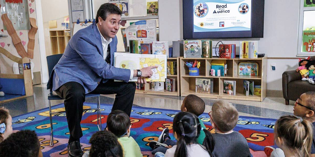 Man Reading Book to Children