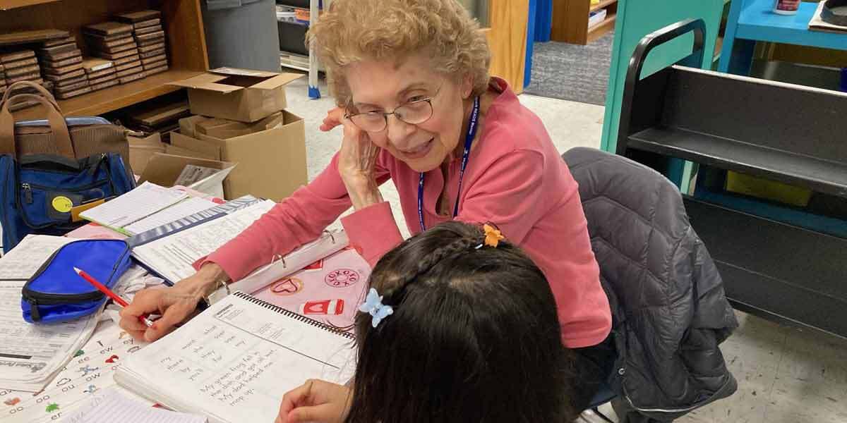 Volunteer Helping Child Write