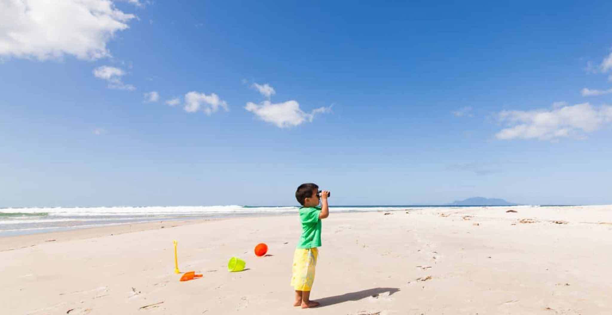 Child Looking Through Paper Binoculars on Beach